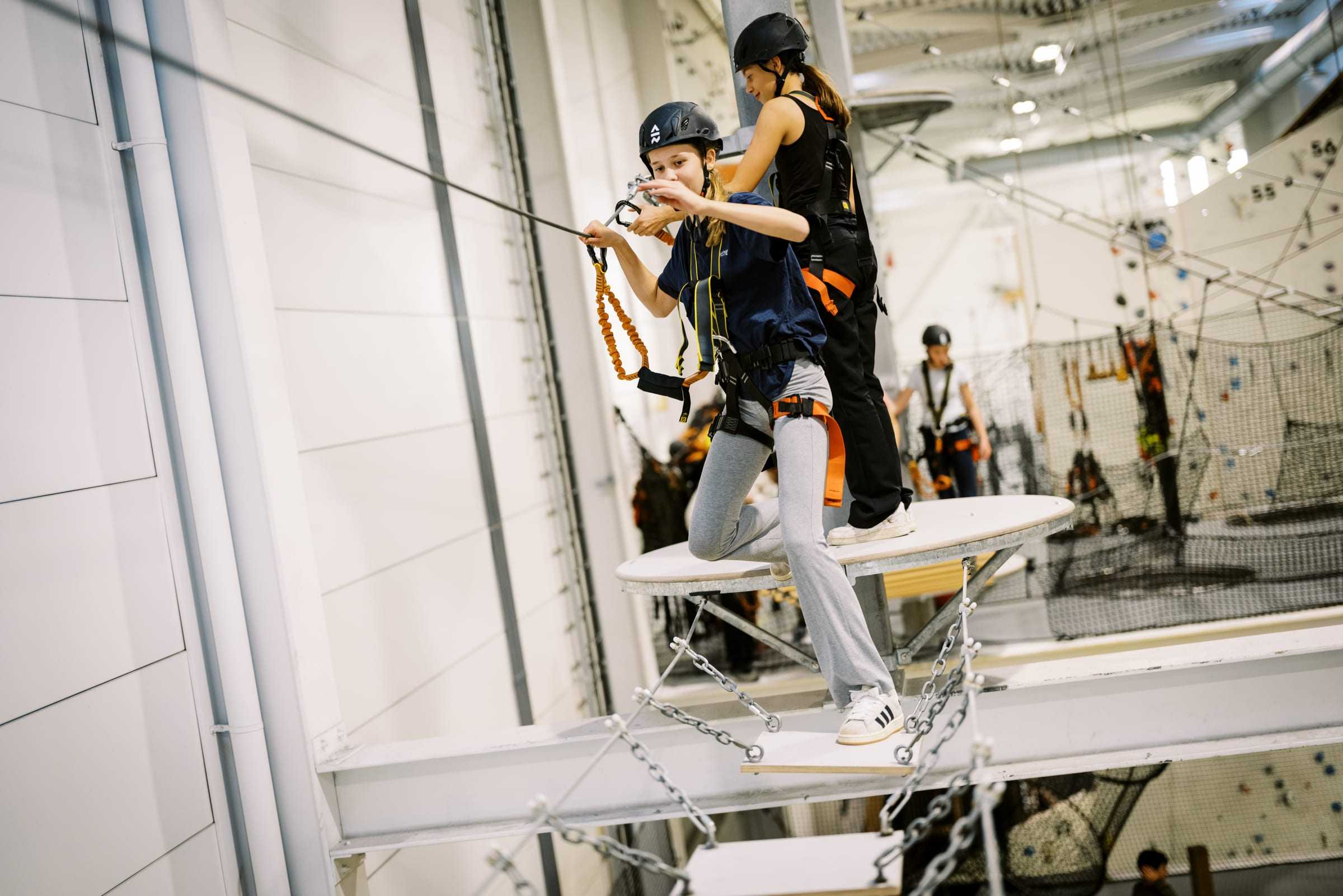 A birthday kid on the high ropes course with an instructor