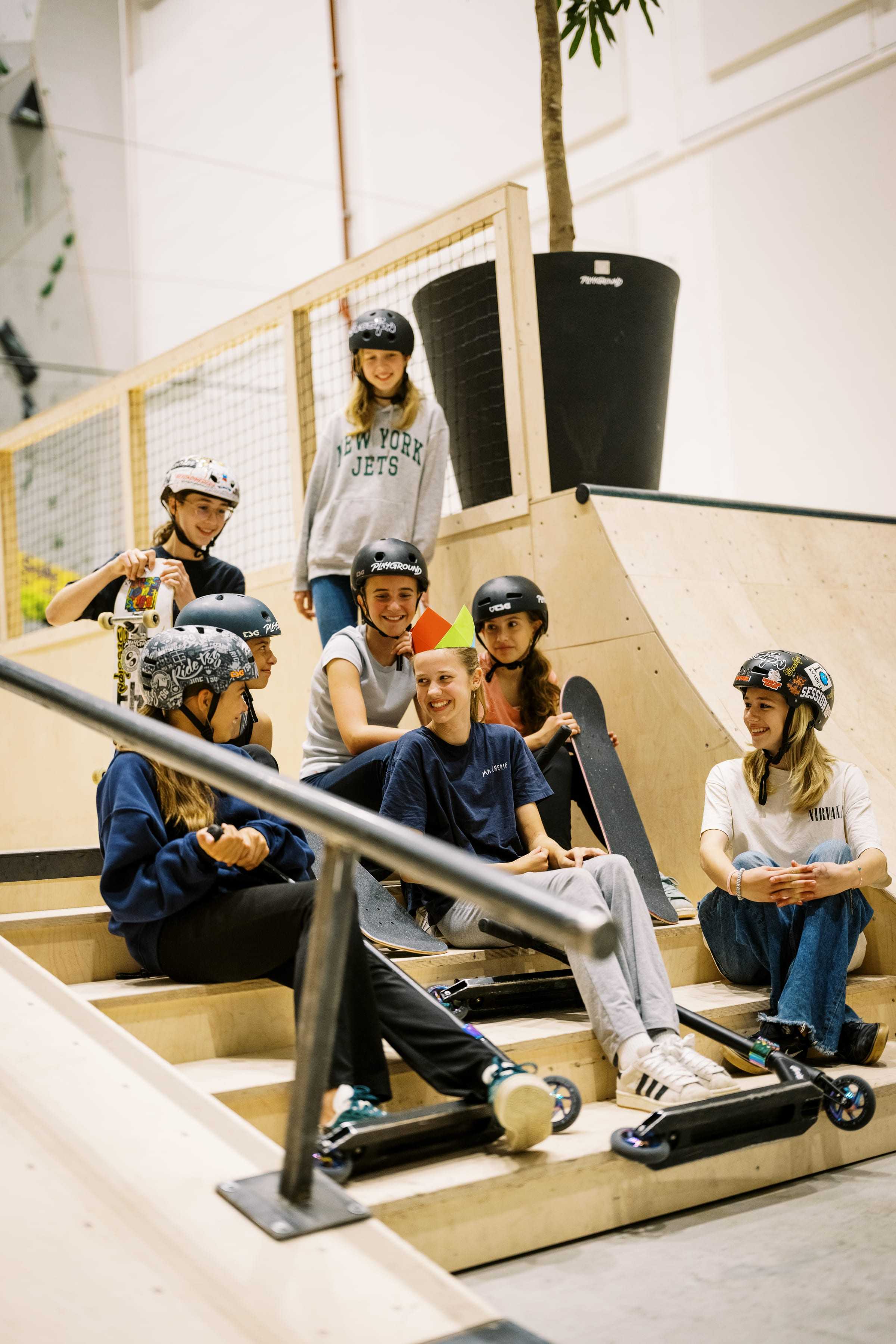 The birthday group together in the skate park with boards and scooters